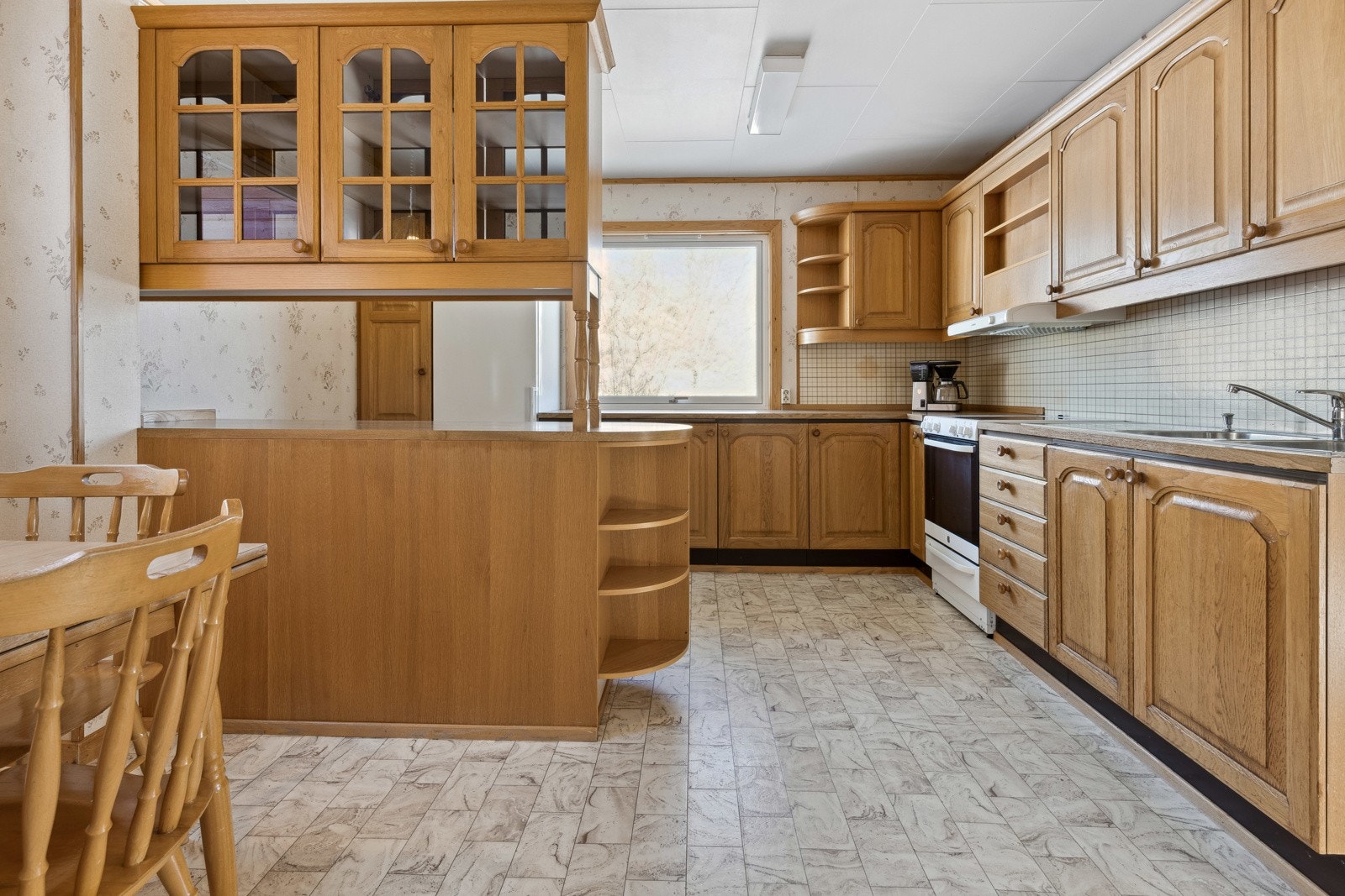 Kjøkkenet ligger i eget rom på enden av stuen, med innredning av profilerte eikefronter og laminat benkeplate. Galleribilde