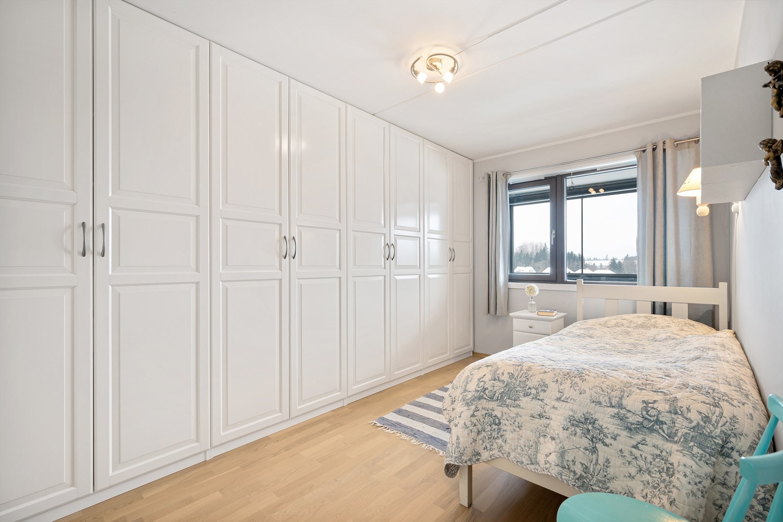 Langs den ene veggen har hoved soverommet et stort garderobeskap med hvite, profilerte fronter. Galleribilde