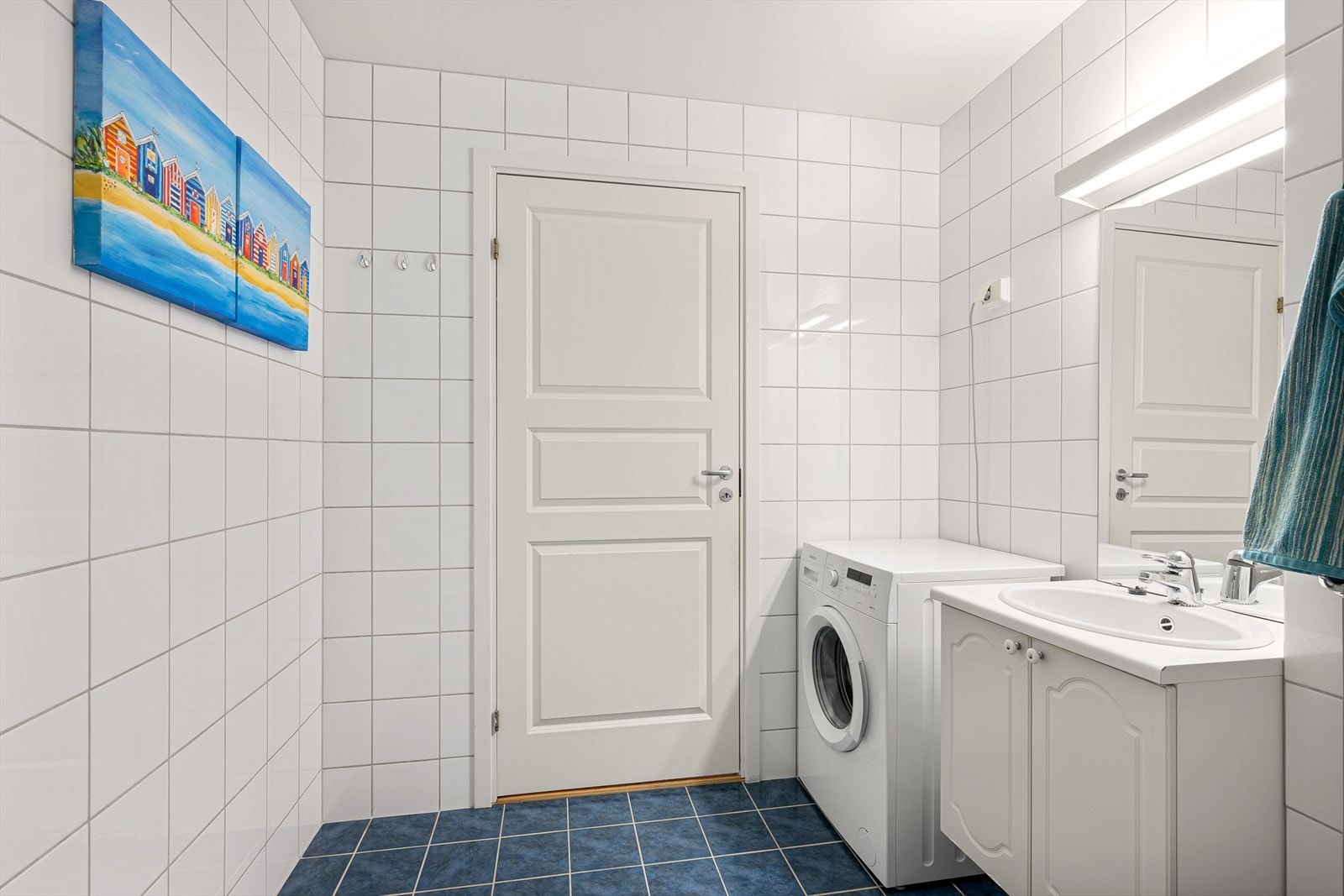 Badet har blant annet servant med hvite underskap, et hvitt høyskap og et speil med belysning. Galleribilde