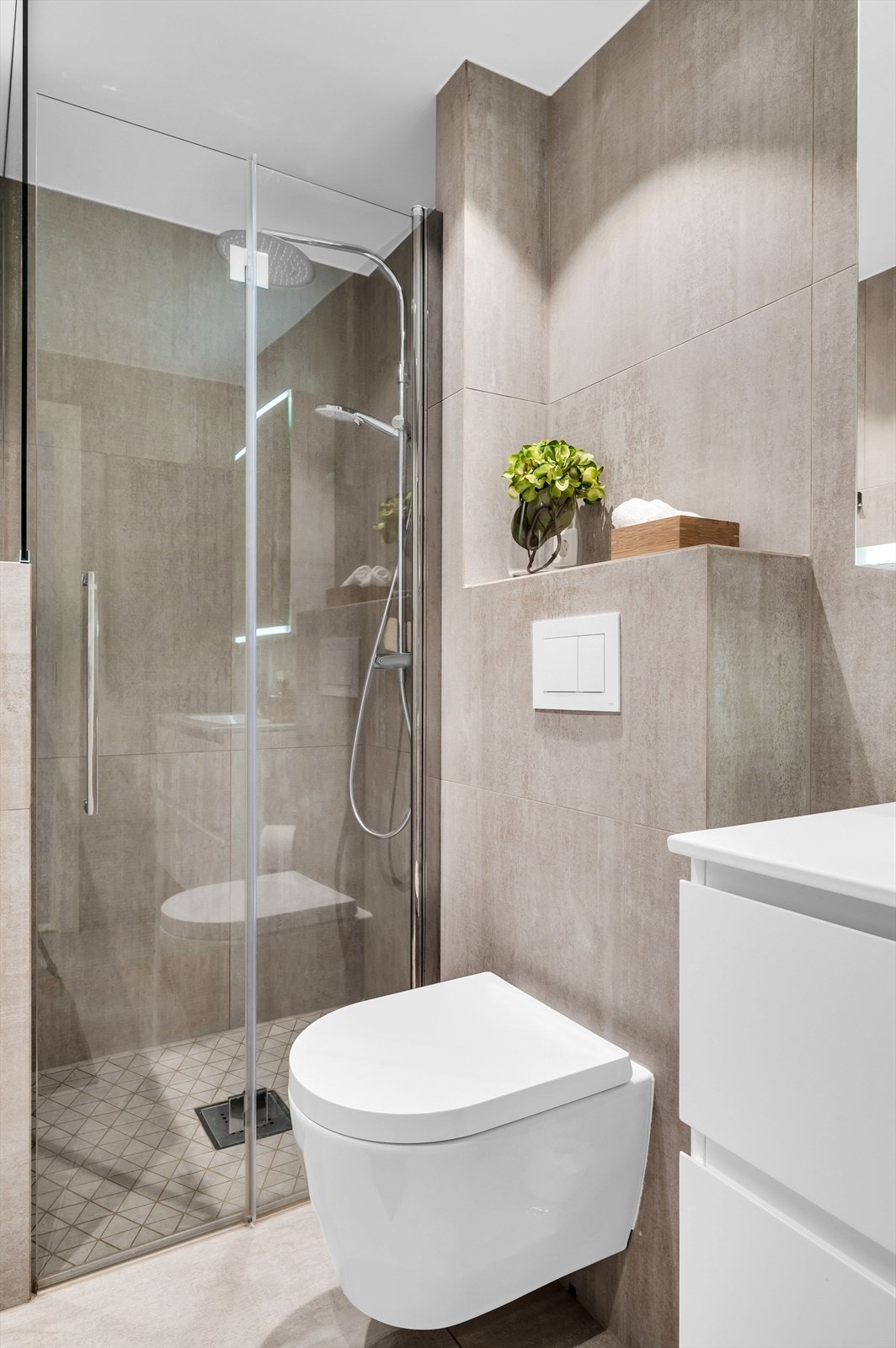 Innredningen består av servant med underskap, overskap med speilfronter og lys, vegghengt toalett, dusjsone med inn-/utadslående dører og opplegg for vaskemaskin. Galleribilde