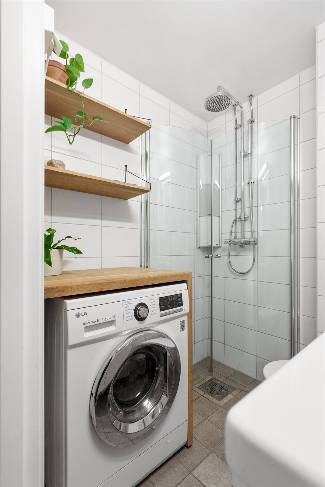 Velkommen til et praktisk og supereffektivt bad. Dusjhjørne med regnfallsdusj, plassbygget benk i heltre eik og avsatt plass til kombinert vaskemaskin og tørketrommel. Galleribilde