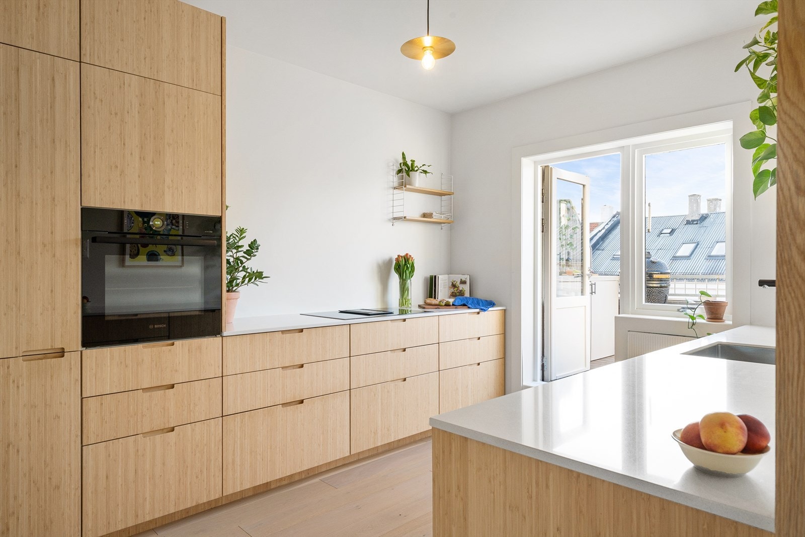 Kjøkkenet ble bygget i 2020 med et ønske om en sosial og åpen sone med plass til både hobbykokker og gjester. Koblingen til både stue og takterrasse gjør dette til et naturlig sosialt midtpunkt i leiligheten. Galleribilde