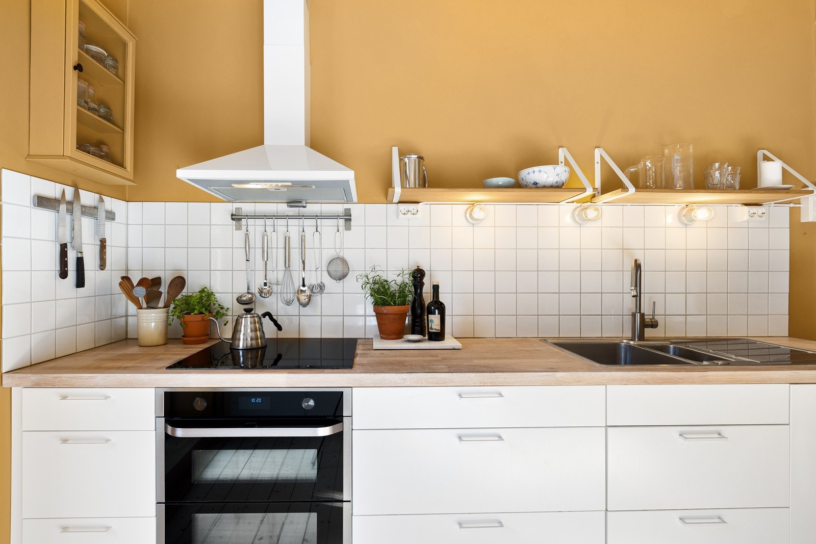Innredningen har benkeplate i heltre med nedfelt kum i rustfritt stål og ettgreps blandebatteri, samt flisfelt over benk. Galleribilde