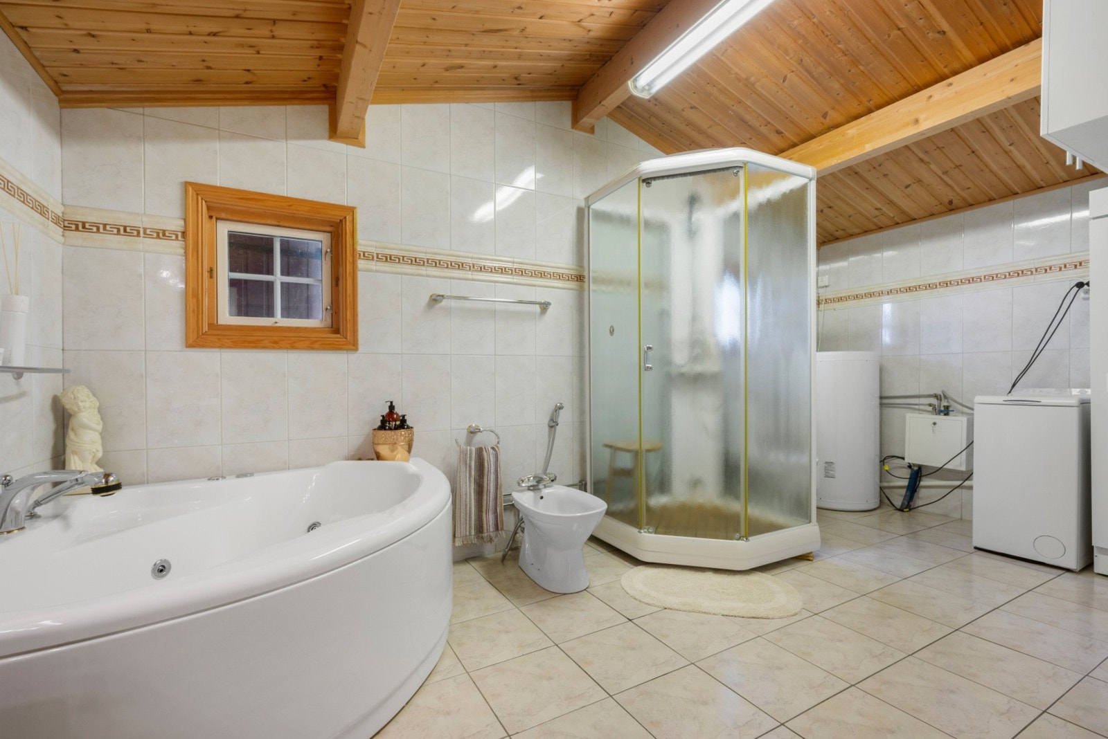 Badet inneholder innredning med dobbel servant, dusjkabinett, vaskemaskin, bide, hjørneboblebad og praktisk tørkeskap. Galleribilde