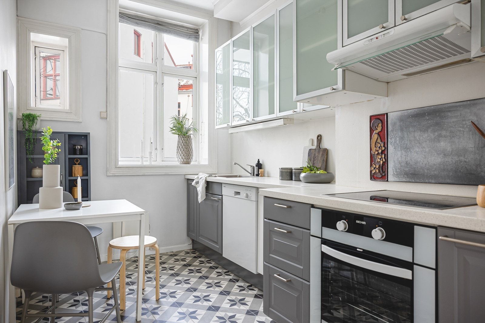 Kjøkkeninnredning består av moderne, laminerte fronter, fronter på overskap i glass og benkeplate i laminat. Galleribilde
