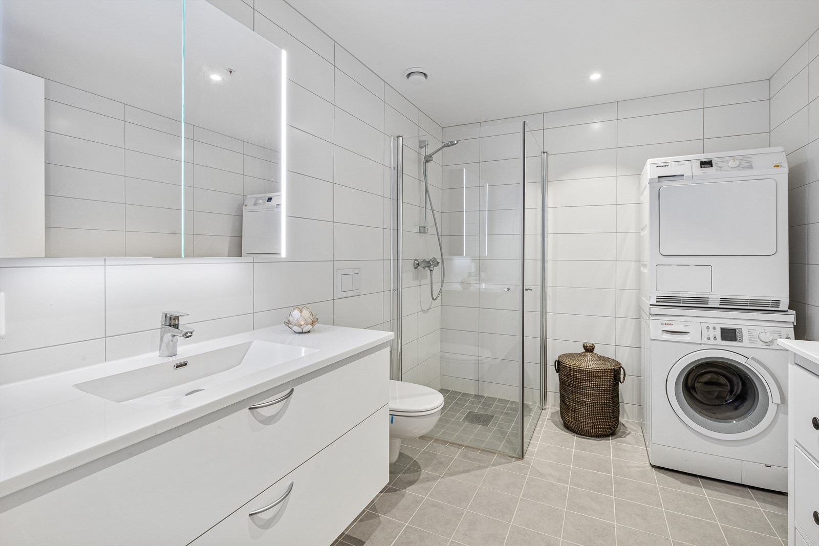 Tiltalende flislagt bade-/vaskerom med gulvvarme Galleribilde