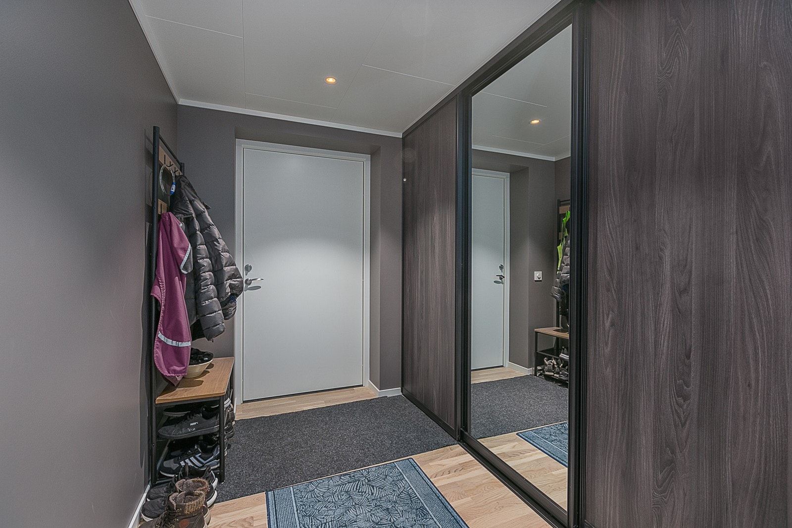 Vindfang med lekker skyvedørsgarderobe for oppbevaring av yttertøy. Galleribilde