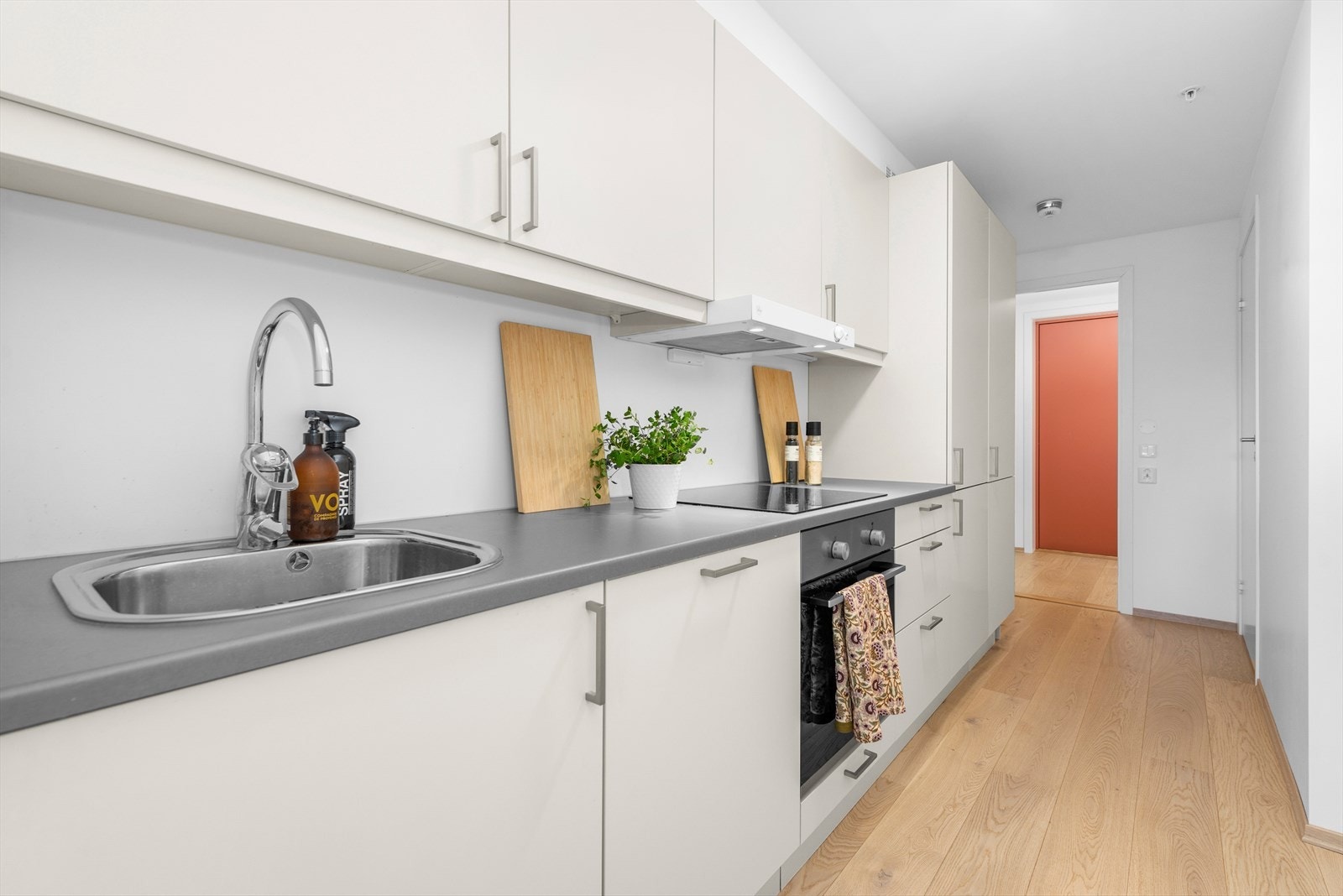 Kjøkkenet har praktisk utforming langs vegg, med god skap- og benkeplass Galleribilde