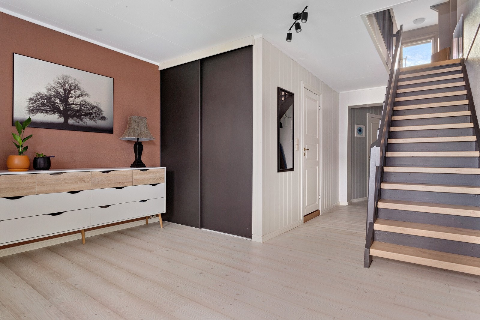 Gangen i 1. etg. har en stilig skyvedørsgarderobe i mørk brun, denne står i stil med trappen til 2. etg. Varmepumpe i gangen Galleribilde
