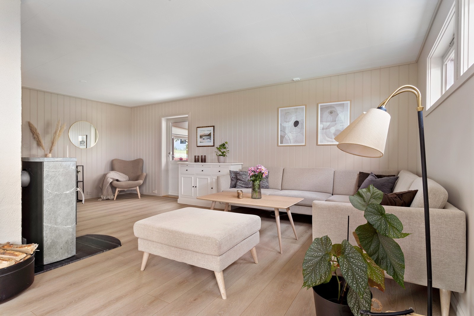 Stuen er stor i størrelse og gir mange muligheter for å dele i soner. Her ser man utgangen til sommerstuen, ny dør i 2019 Galleribilde