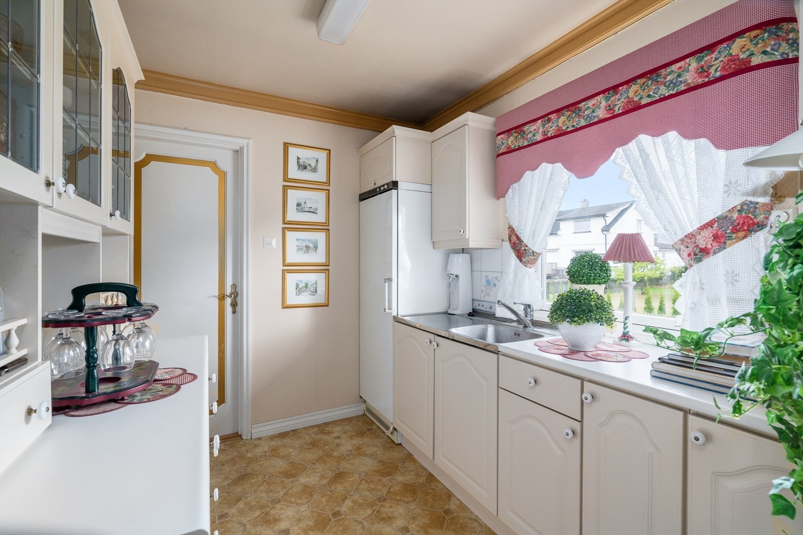 Grovkjøkken som har godt med skapplass samt benkeplate med vask Galleribilde