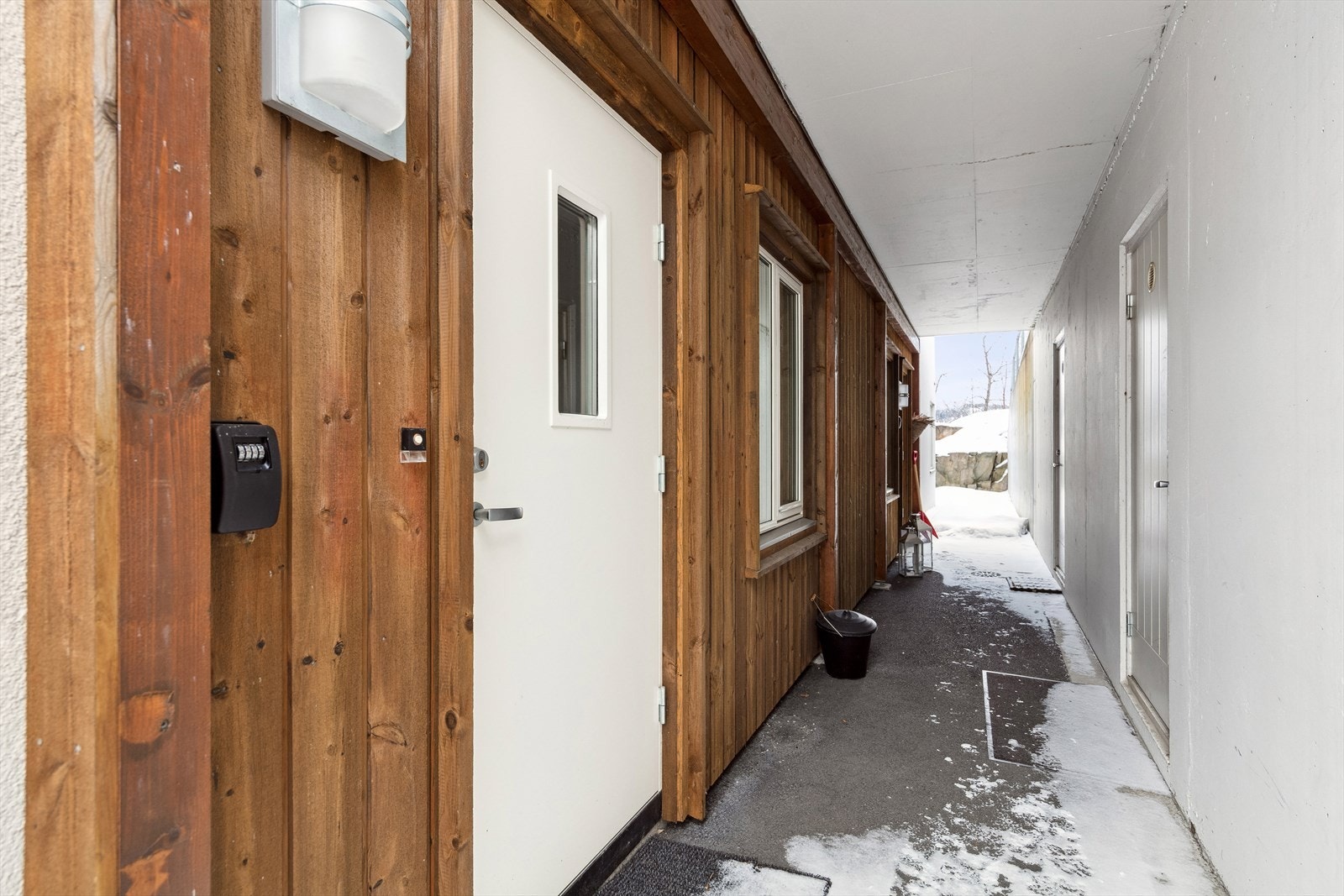 Overbygget inngangsparti, med ekstern bod rett ved inngangen. Galleribilde