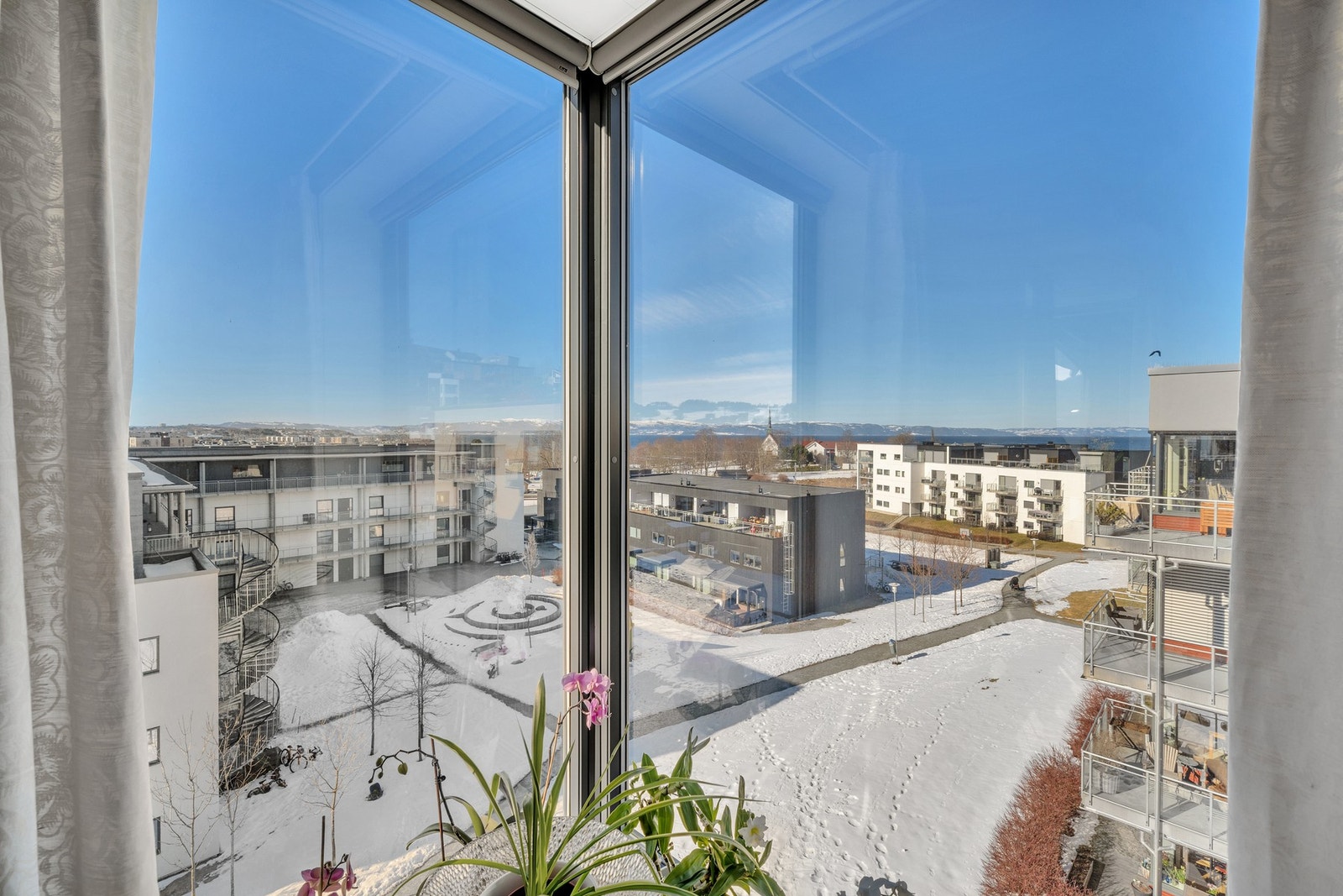 Her har man en fantastisk utsikt fra stua via store hjørnevinduer. Dette bidrar til å gi leiligheten en helt spesiell atmosfære. Galleribilde