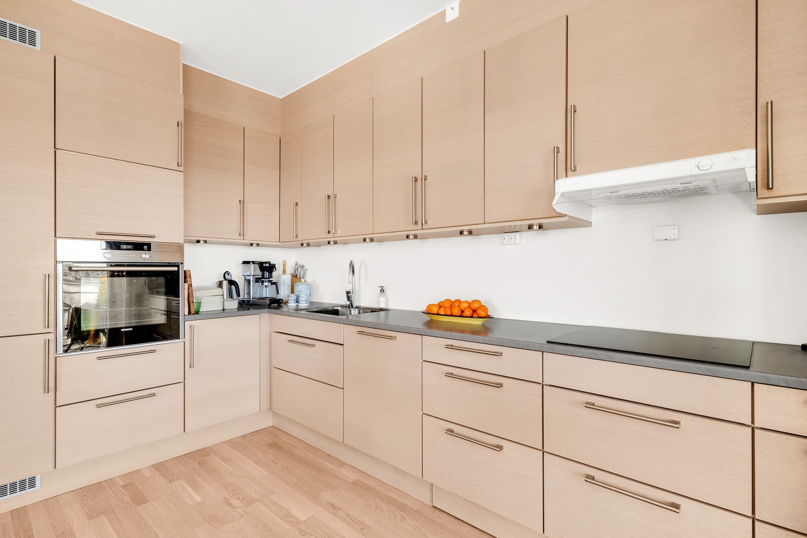 Kvalitetskjøkken fra HTH i eik med integrerte hvitevarer som platetopp, stekeovn, oppvaskmaskin og kjøle/fryseskap. Galleribilde