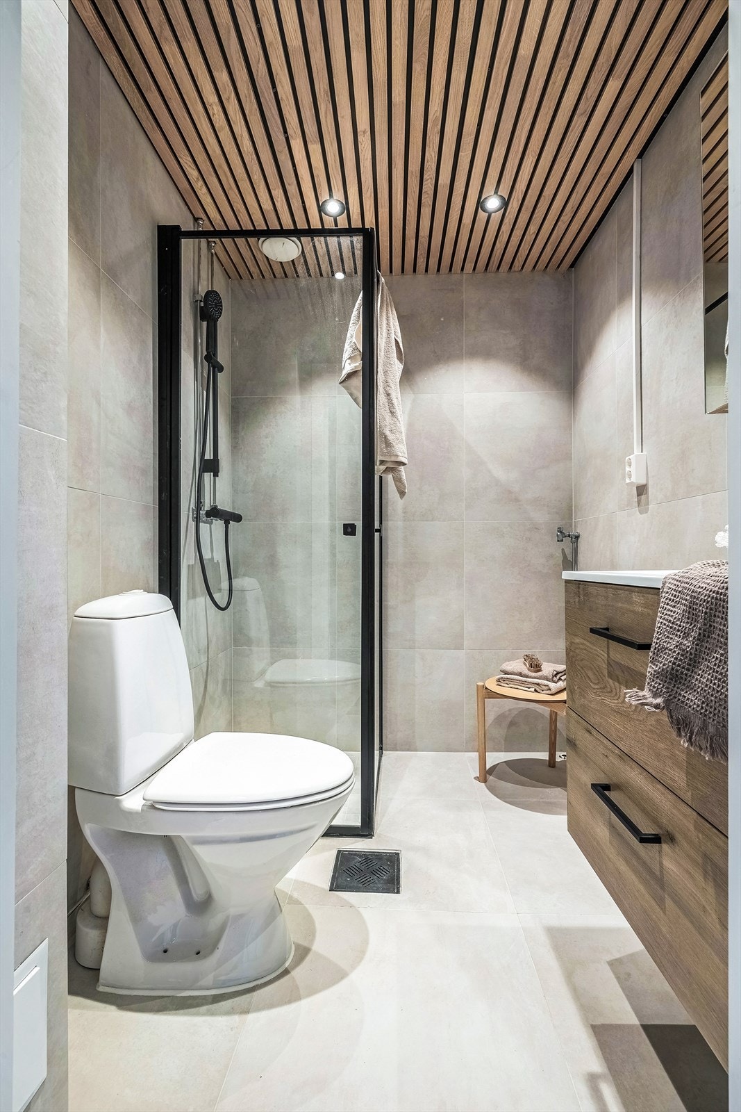 Badet har lekre detaljer som eikespiler langs hele taket og matchende servantinnredning. Galleribilde