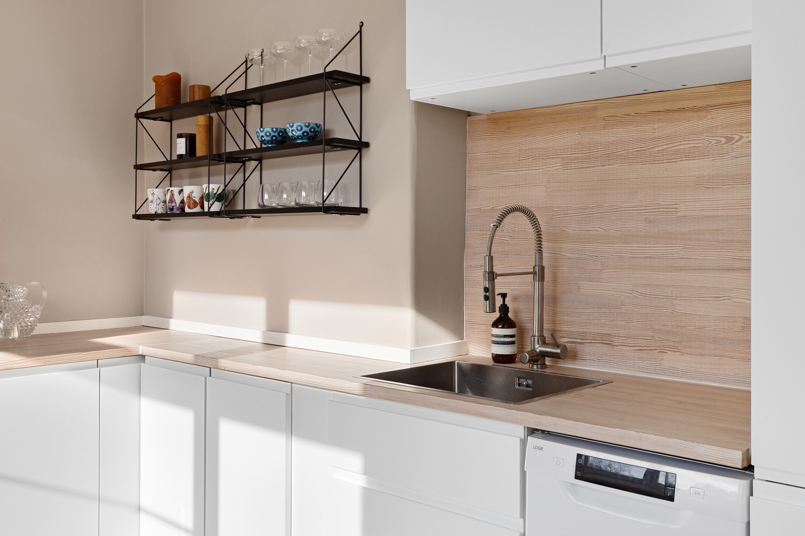 Kjøkkenet består av glatte fronter, heltre benkeplate, integrerte hvitevarer som platetopp, stekeovn og kjøl/frys. Galleribilde