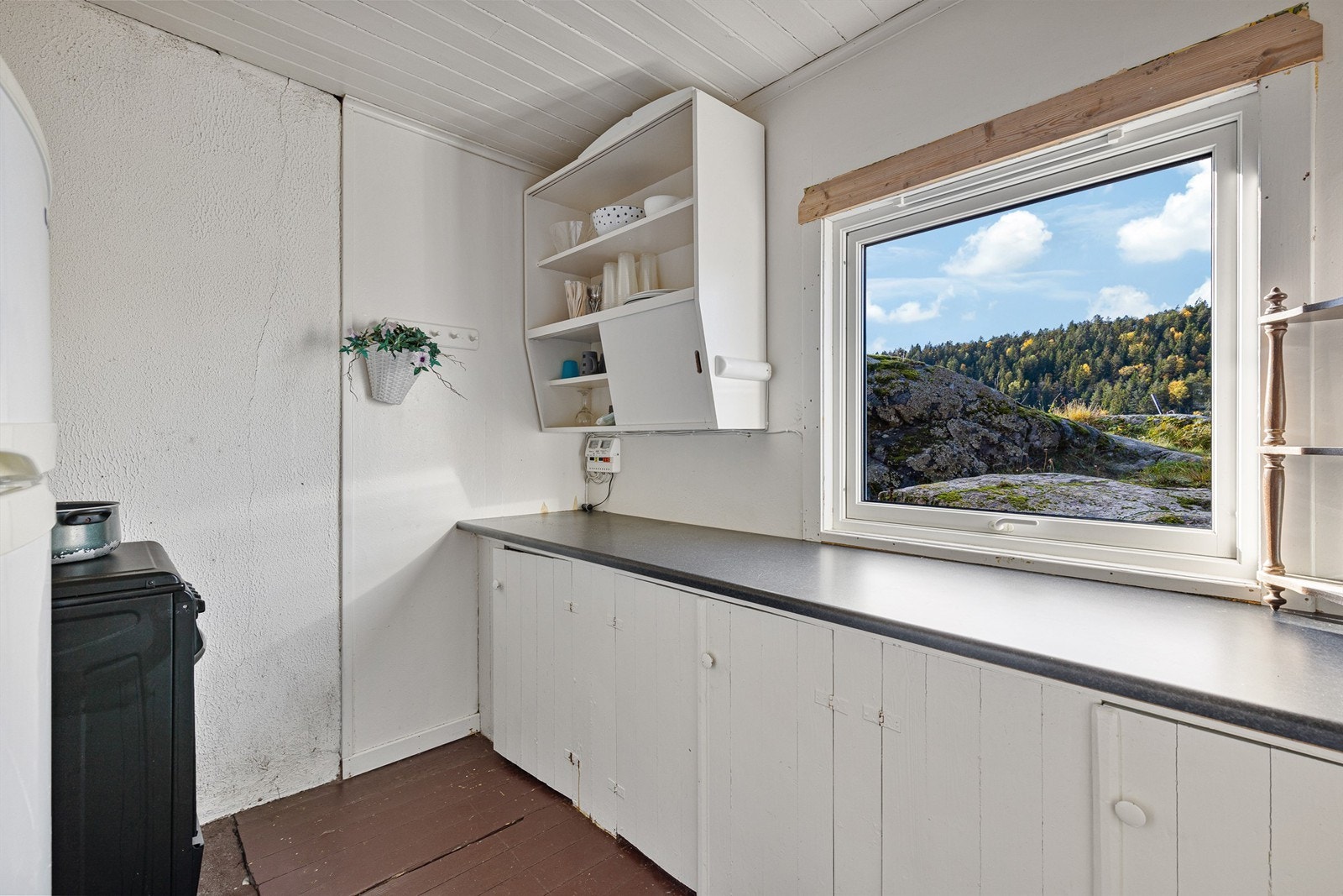 Kjøkken med oppgraderingsbehov. Om sommeren står vinduet på gløtt og trekker inn deilig og frisk sjøluft. Galleribilde