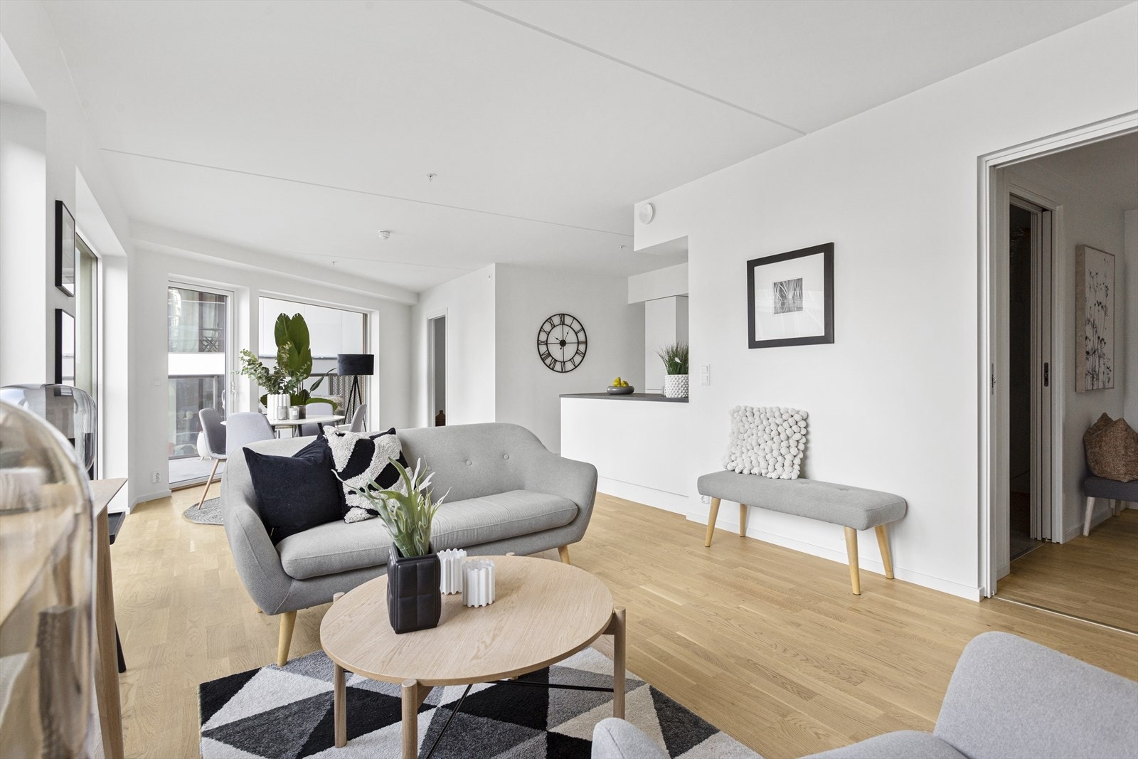 De hvite overflatene kombinert med parkettgulv og vinduer som strekker seg fra gulv til tak, gjør at rommet framstår romslig med en åpen atmosfære. Galleribilde