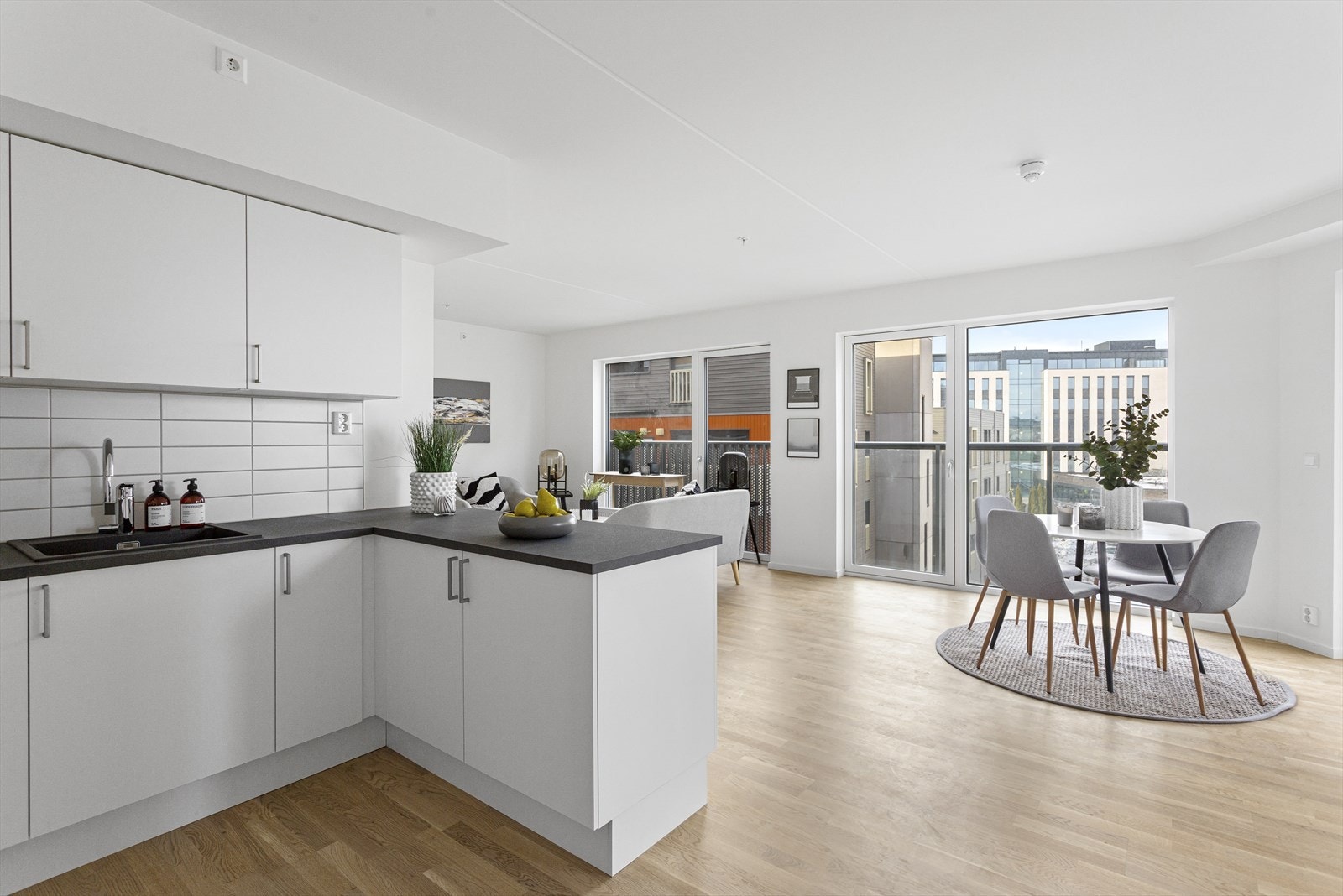 Klassisk hvit kjøkkeninnredning i praktisk U-form. Den åpne løsningen mot stuen gir et luftig og sosialt oppholdsrom med plass til spisebord. Galleribilde