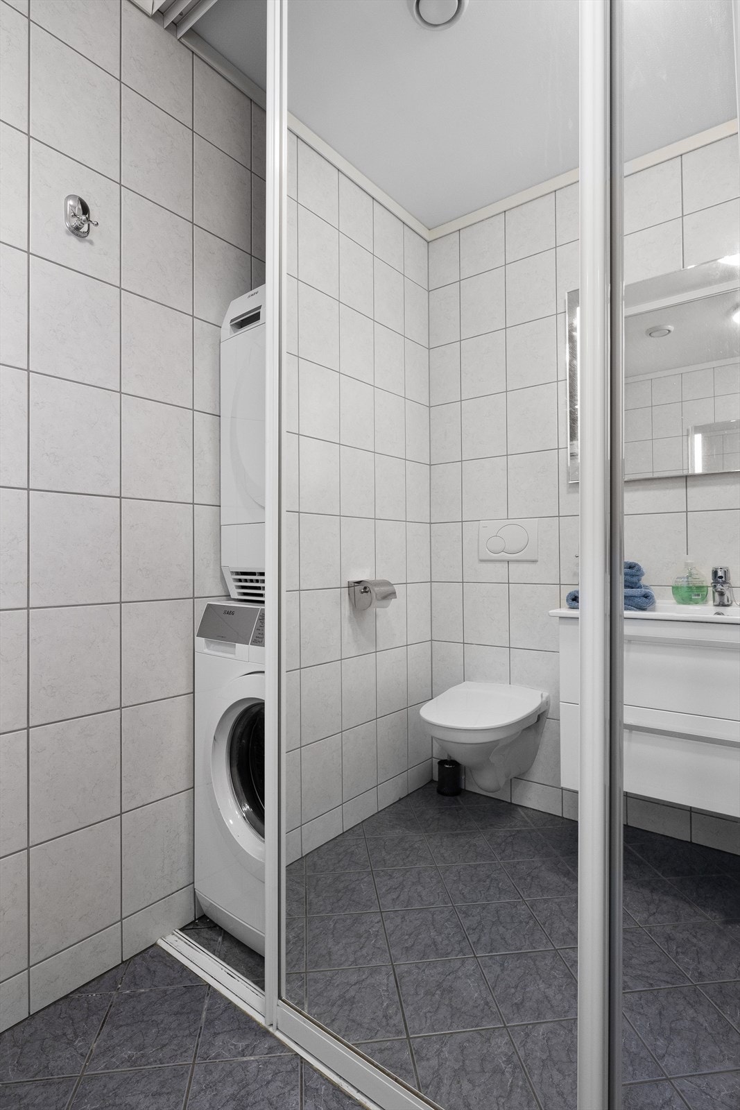 Vaskemaskin bak skyvedører i badet i under etasjen Galleribilde