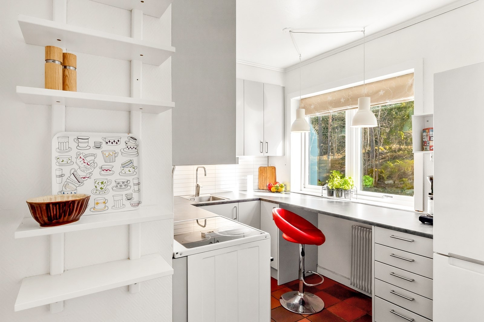 Kjøkkenet vender ut mot rolige og grønne omgivelser. Flislagt gulv. Galleribilde