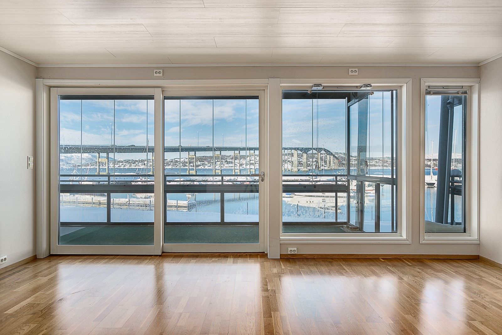 Utgang til innglasset veranda fra stuen via skyvedører. Galleribilde