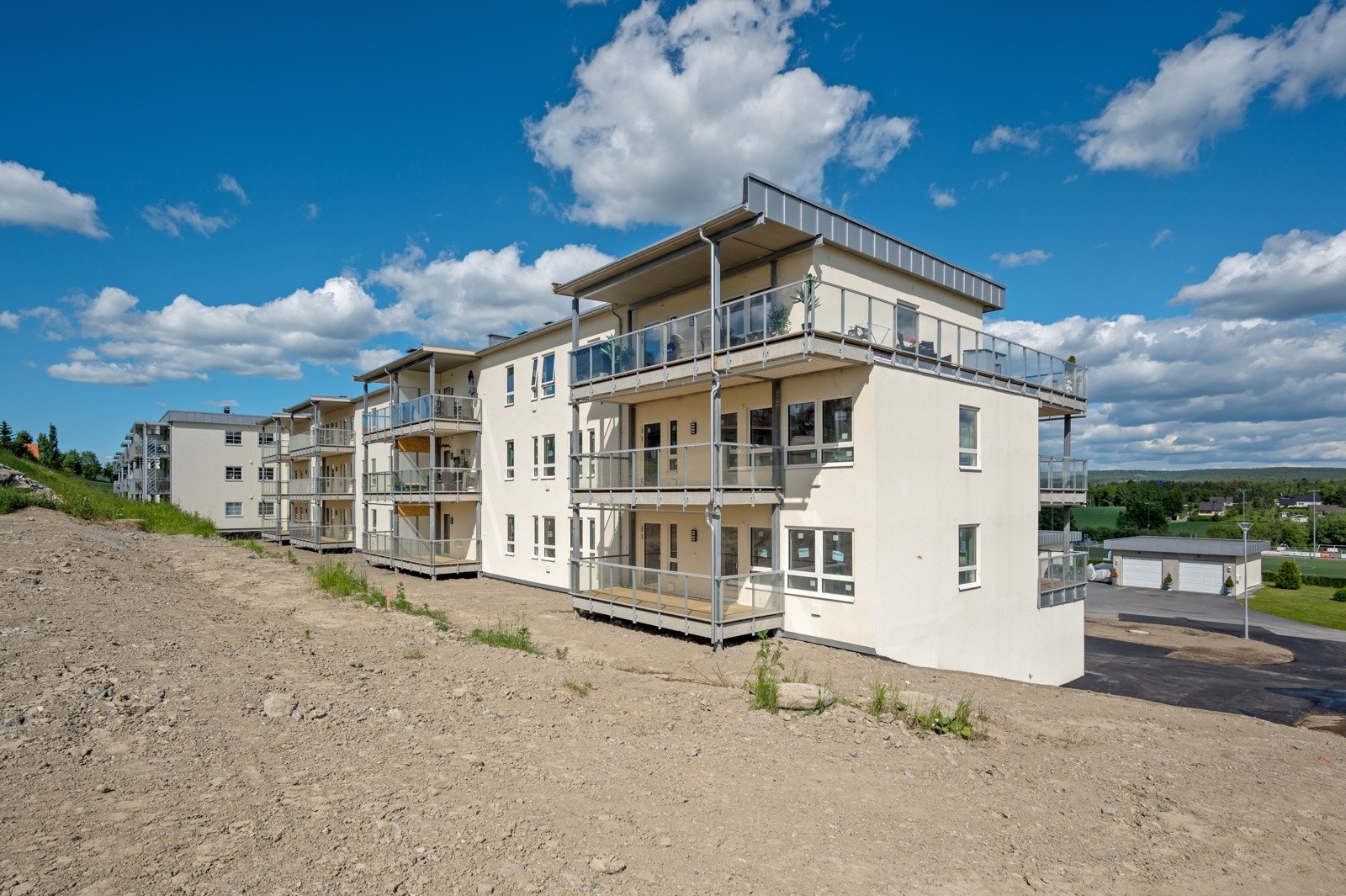 Tomten er opparbeidet med asfalterte adkomstveier og parkeringsplasser, samt noe plenarealer og beplantning for de tidligere byggetrinnene. Galleribilde