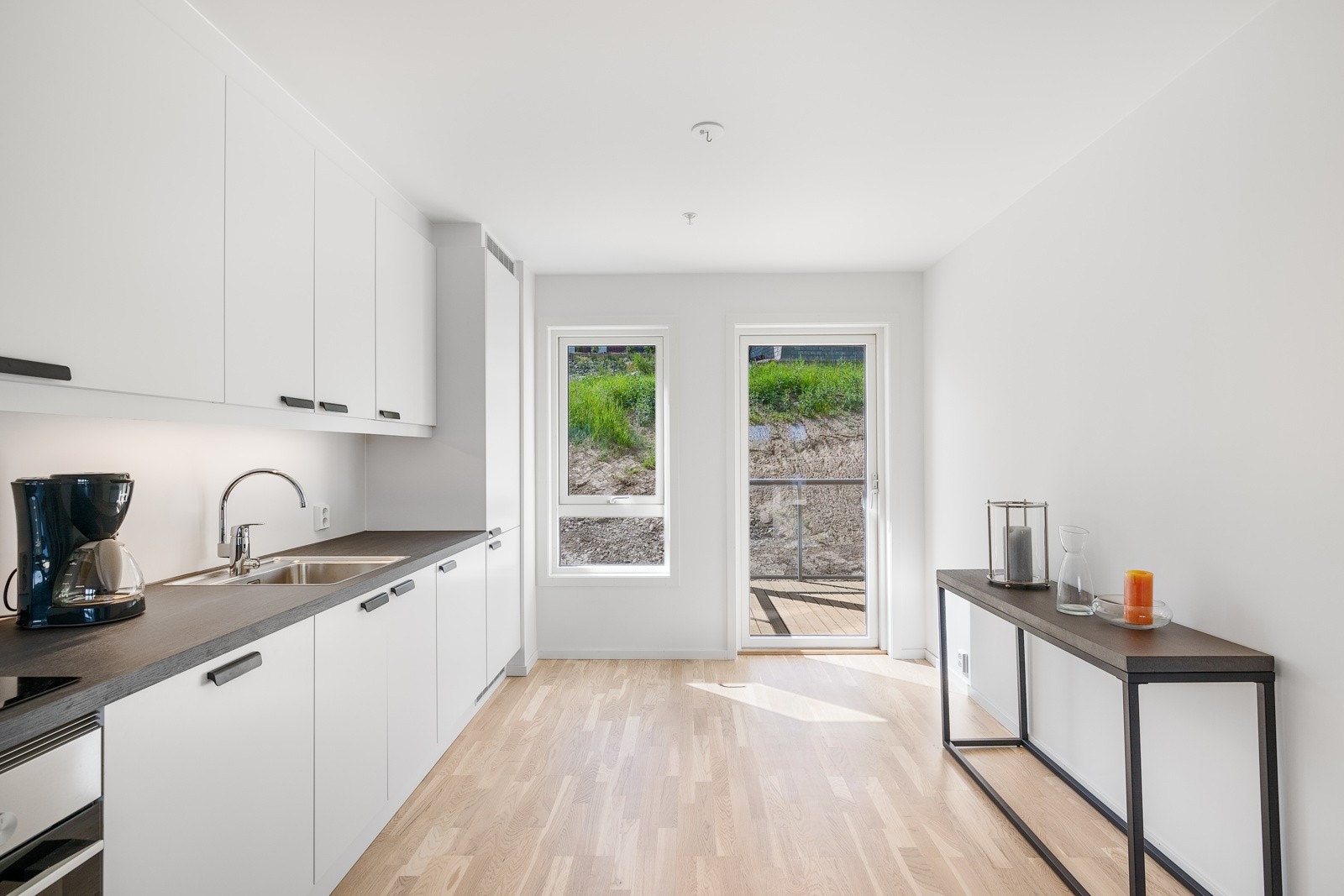 Fra kjøkkenet er det utgang til den minste av leilighetens to balkonger. Galleribilde