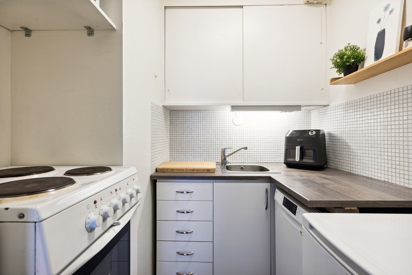 Kjøkkenet har innredning med hvite glatte/malte fronter, laminat benkeplate med skyllekum og ettgreps blandebatteri. Galleribilde