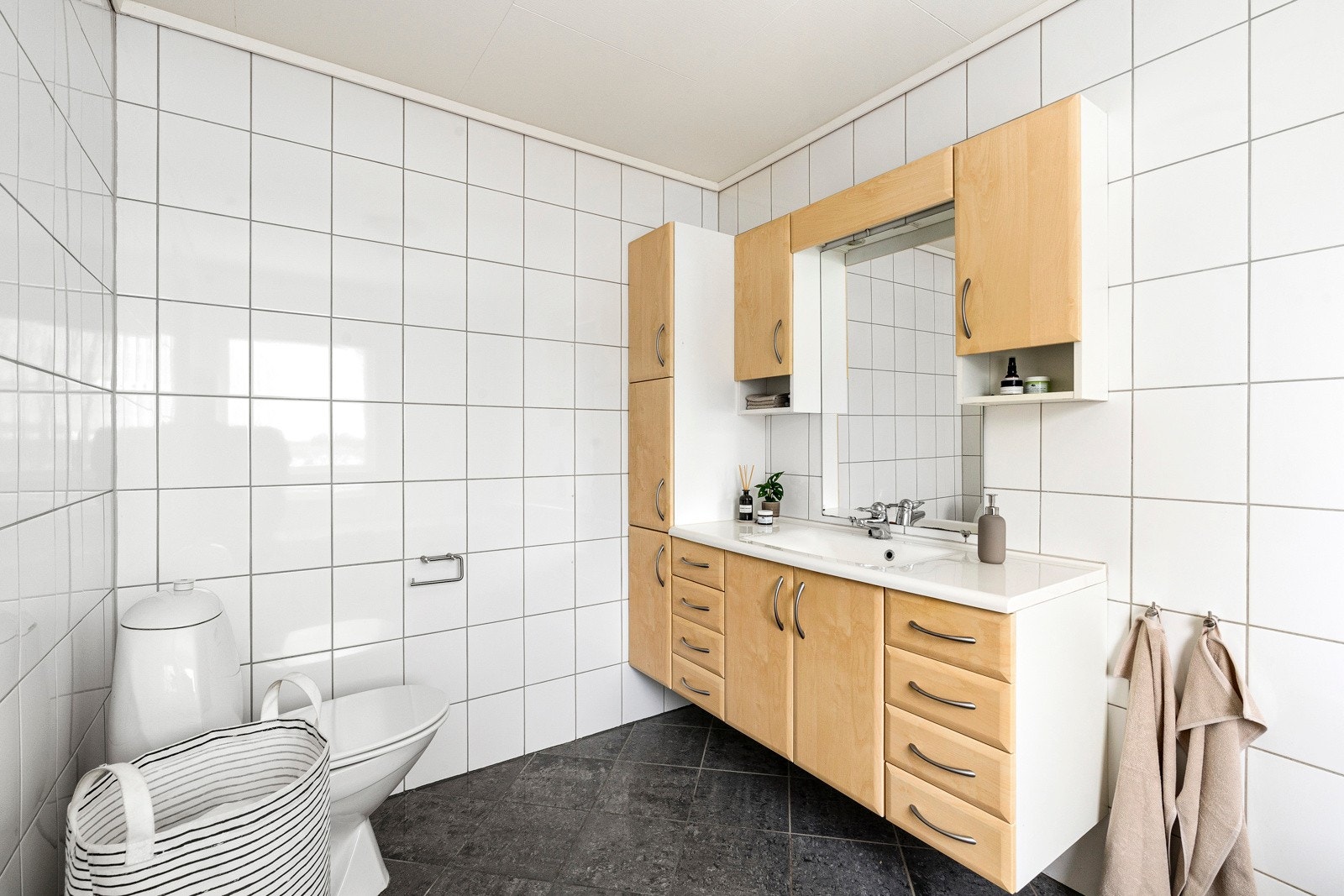 Baderommet er fliselagt på gulv og vegger, og utstyrt med seksjon med hel servant, toalett og badekar. Galleribilde
