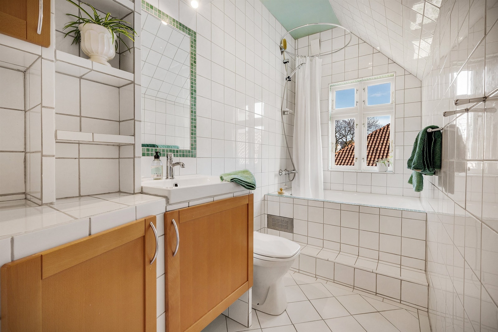 Sjarmerende, lyst, helfliset bad med integrert badekar og servant. Gulvvarme Galleribilde