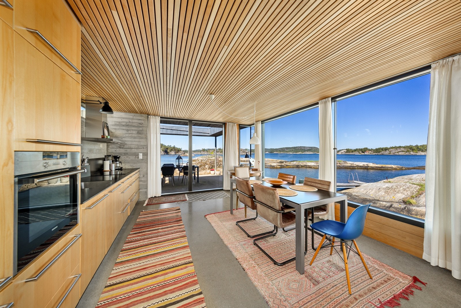 Store vindusflater mot sjøen - Spisestue/kjøkken med direkte utgang til terrassen Galleribilde