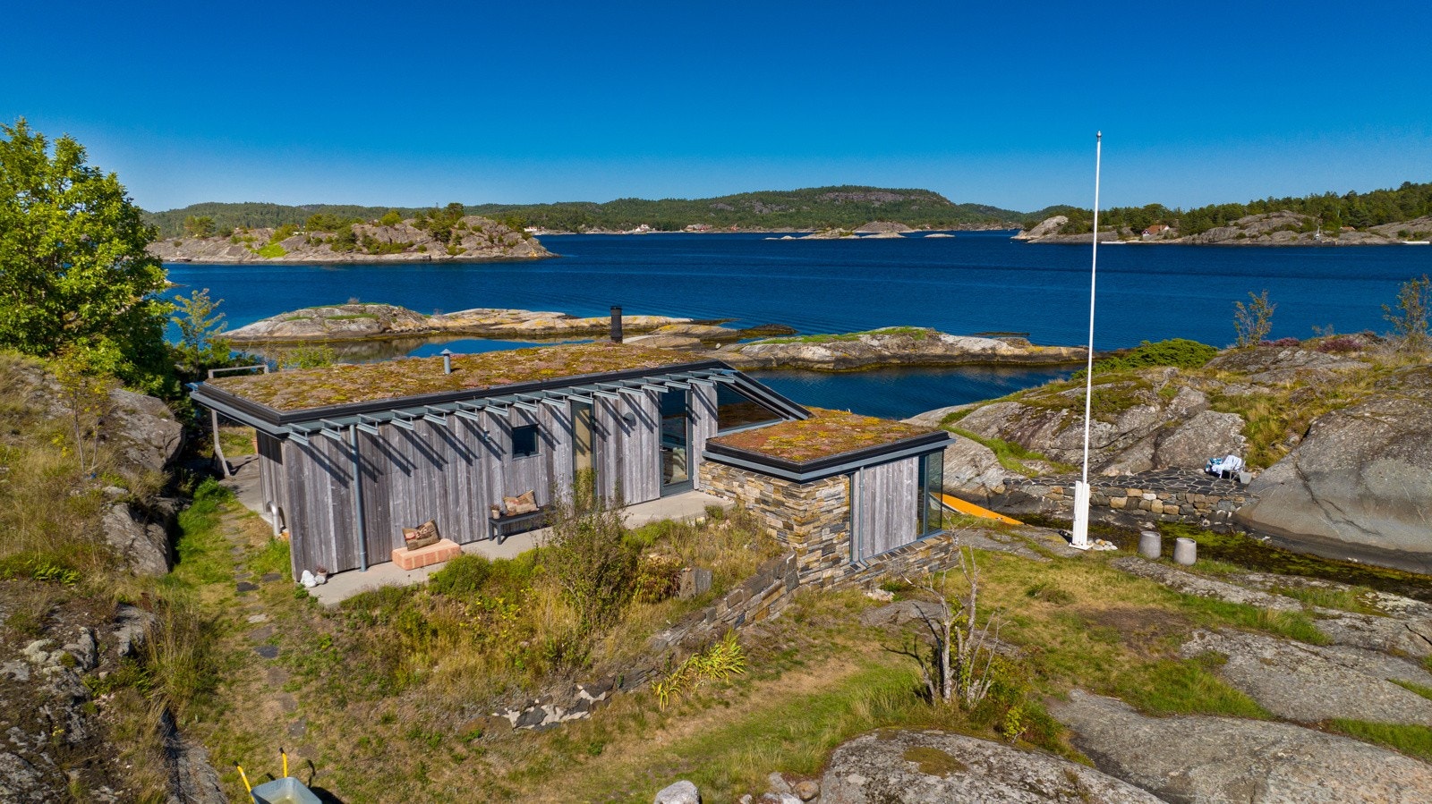 Fokus på vedlikeholdsfrie materialer, ubehandlet treverk og sedum-vegetasjon på taket gjør at hytta går i ett med naturen Galleribilde