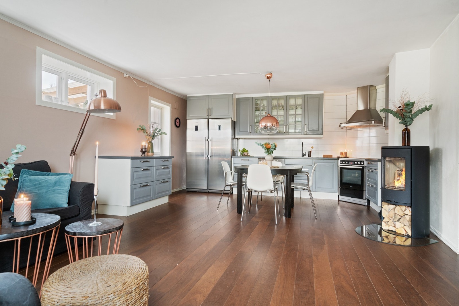 Leilighetens sosiale sone er malt i en varm tone og med plass til både avslapning og bespisning Galleribilde