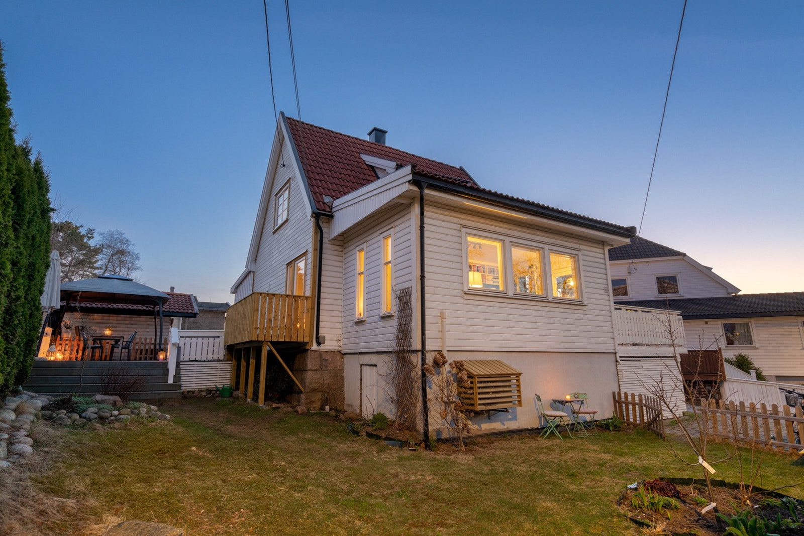 Passe stor tomt med parkering i oppkjørsel med el.- bil lader og hage med gressplen og diverse busker og beplantning. Galleribilde