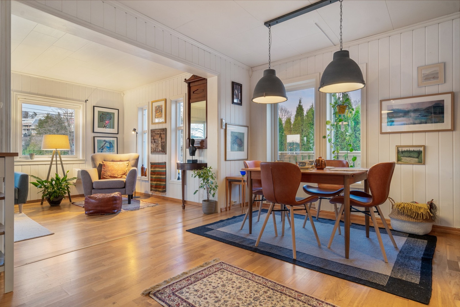 Lys og lun stue i åpen løsning og store vindueflater Galleribilde