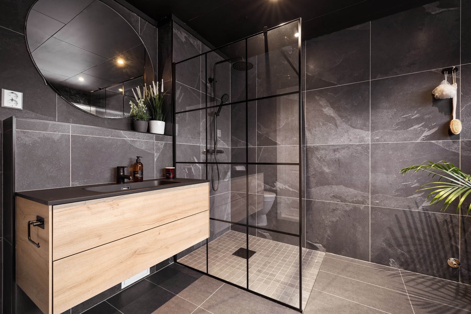 Dette er et rålekkert bad som er oppusset i 2022. Her får man virkelig ''spa-feelingen''. Legg merke til himling som er malt i lik mørk stil som resten av designet på badet. Galleribilde