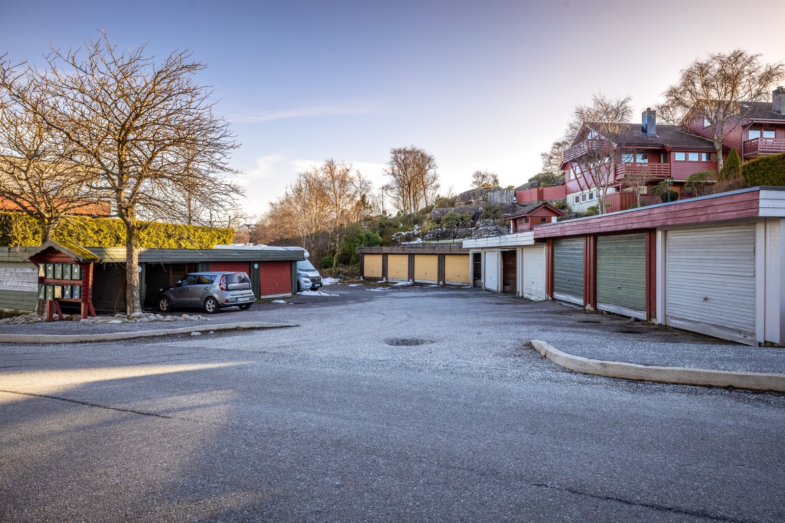 Fast parkeringsplass i egen garasje. Garasjen på enden nærmest postkassene tilhører denne boligen. Galleribilde