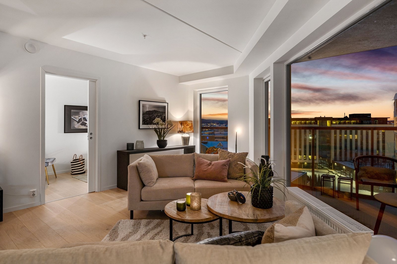 Kveldsstemning i luftig stue med store vinduer og utgang til balkongen. Galleribilde