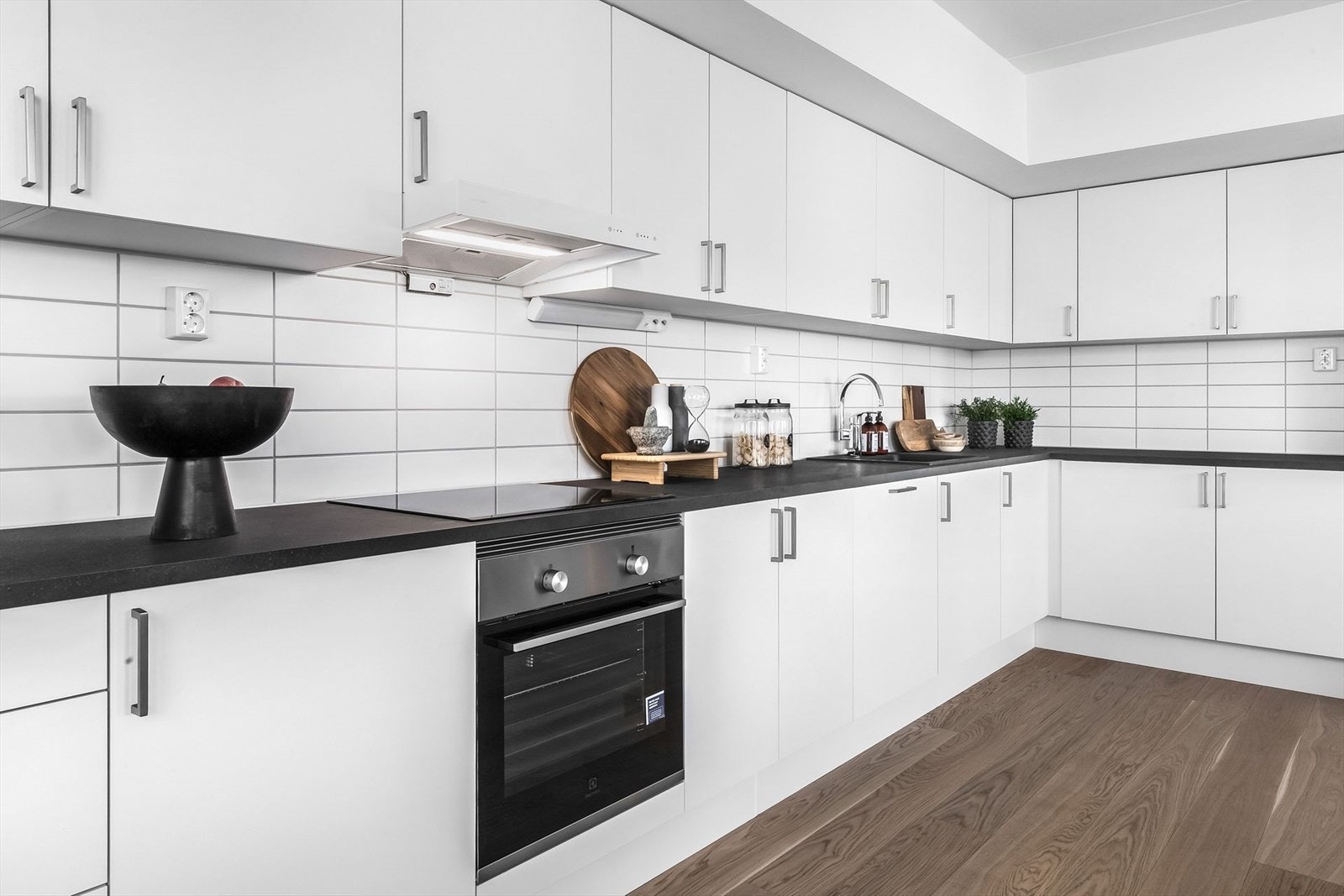 Innredningen er tradisjonell med hvite fronter, laminat benkeplate og flislagt sprutsone. Galleribilde