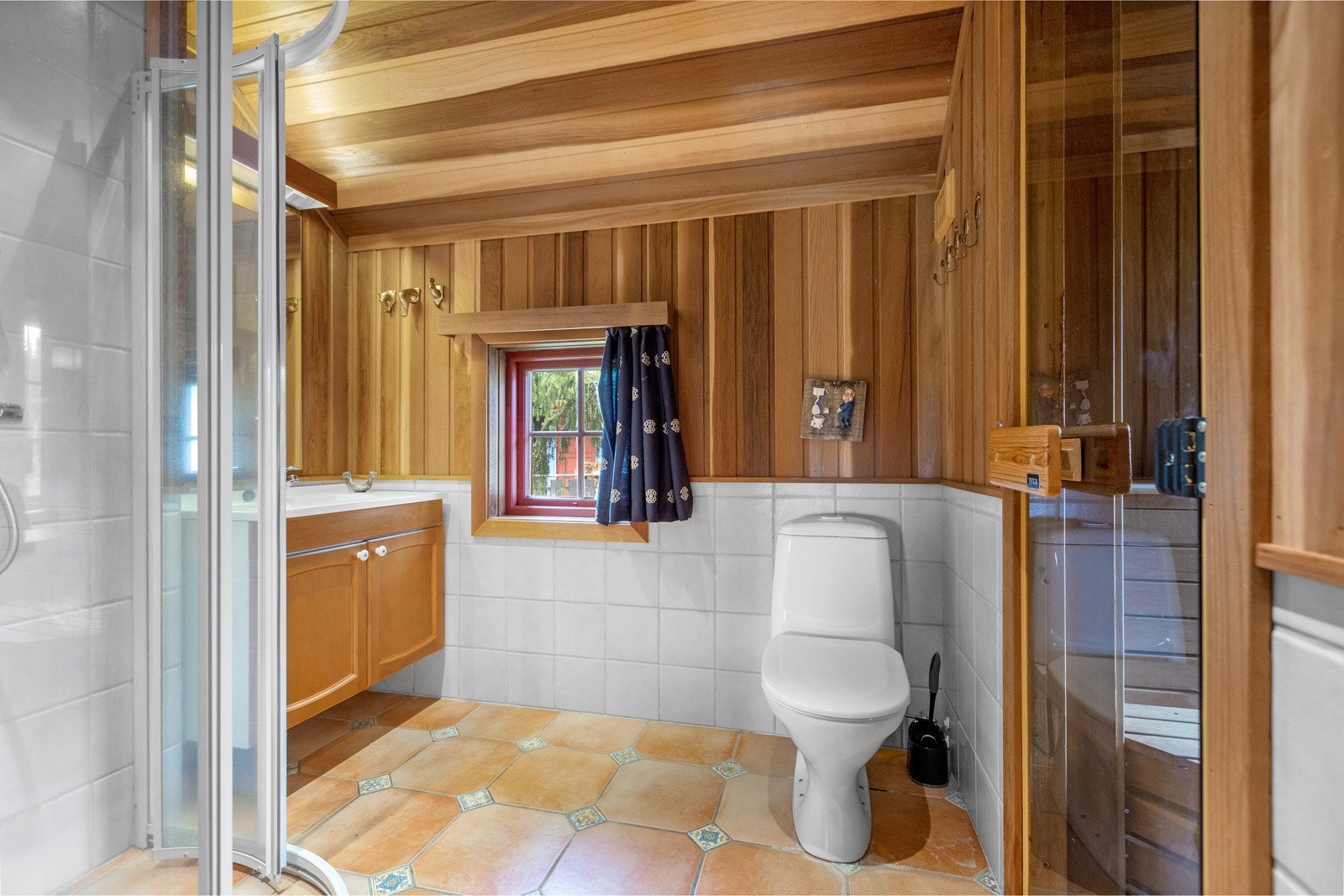 Badet i annekset har en kombinasjon av flis og panel på veggene, himling med panel og flis på gulv. Galleribilde