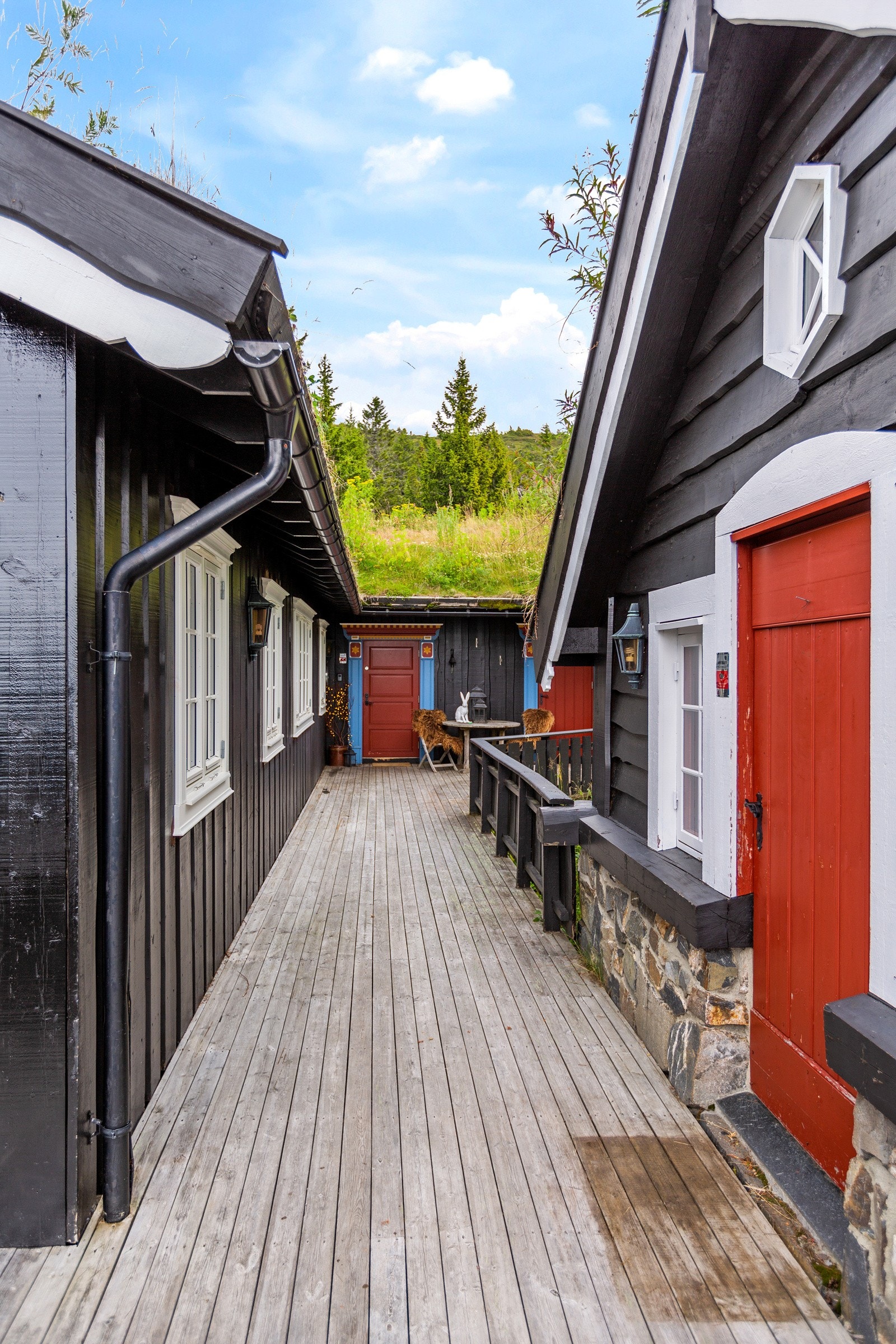 Hytte og anneks bindes sammen med verandaen mellom seg. Galleribilde