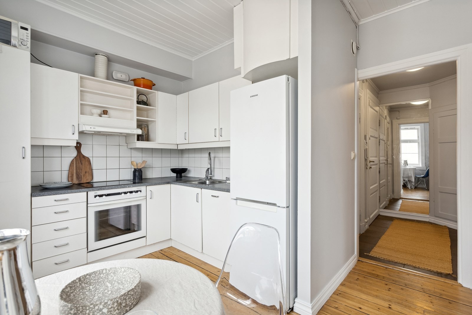 Stilren IKEA kjøkkeninnredning med glatte, hvite fronter, laminat benkeplate. Galleribilde