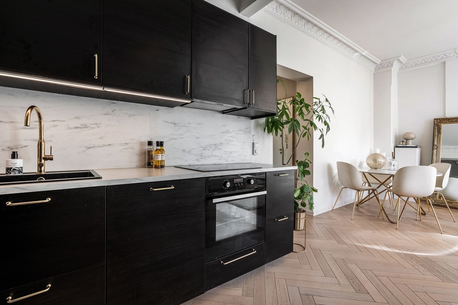 Tidsriktig kjøkkeninnredning fra 2017 med glatte fronter og belysning under overskap Galleribilde