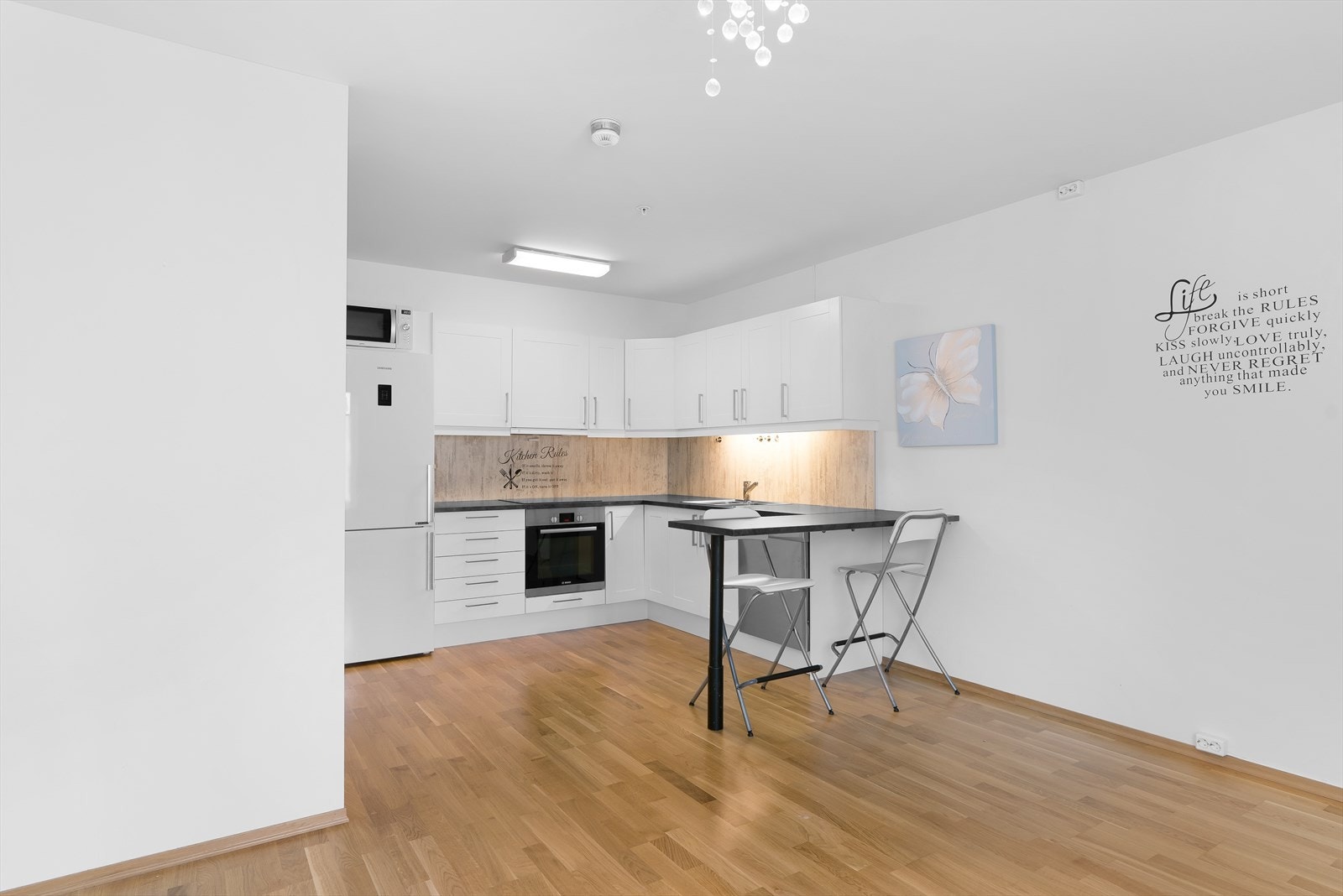 Kjøkken med hvit innredning og mørk laminat benkeplate. Galleribilde