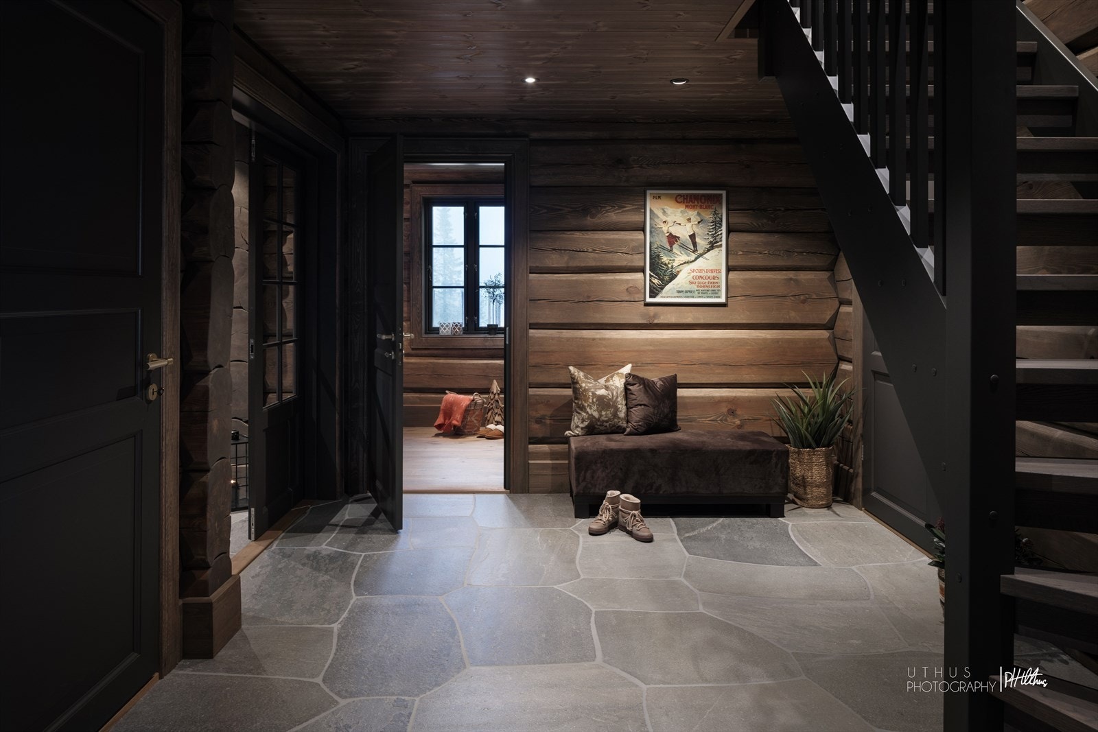 Videre kommer vi inn i en luftig hall med laftede tømmervegger og kontrastvegg med tapet fra Ralph Lauren. Trappen er spesialtegnet for Chalet De Luxe med trappekasse i furu med og trinn i eik (dekorvoks fra Osmo). Galleribilde