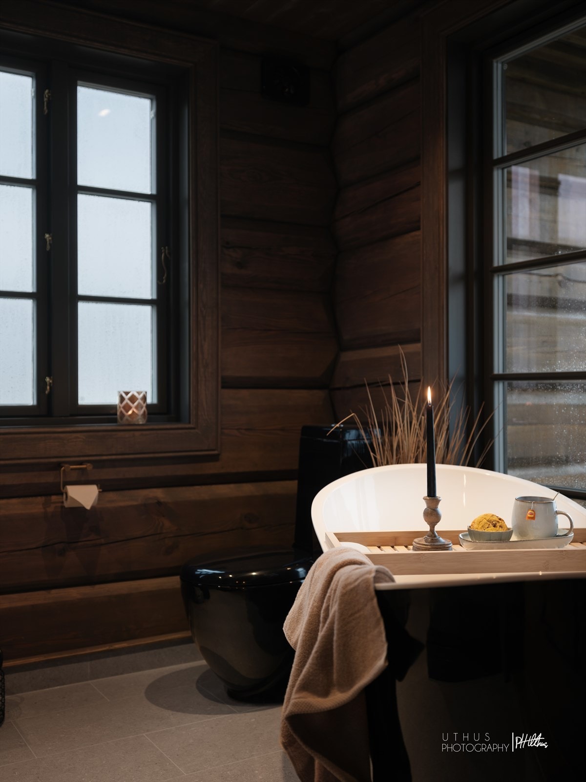 I suiteløsning med soverommet ved stuen er det et herlig bad med laftede tømmervegger, en flissatt kontrastvegg og beige fliser fra Interiørsenteret Valdres på gulv med gulvvarme. Galleribilde