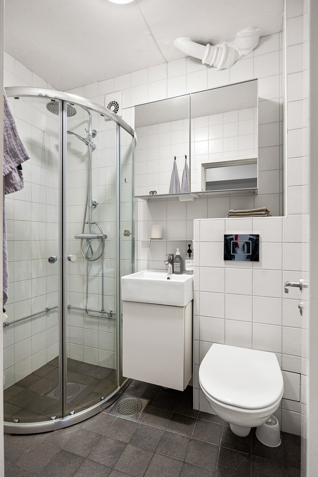 Baderom med flislagte overflater, gulvvarme og opplegg for vaskemaskin Galleribilde