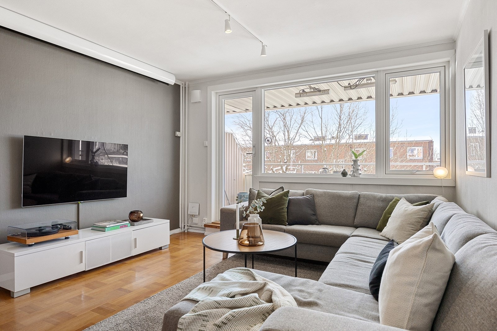 Leiligheten har en lys og innbydende stue med store vindusflater Galleribilde