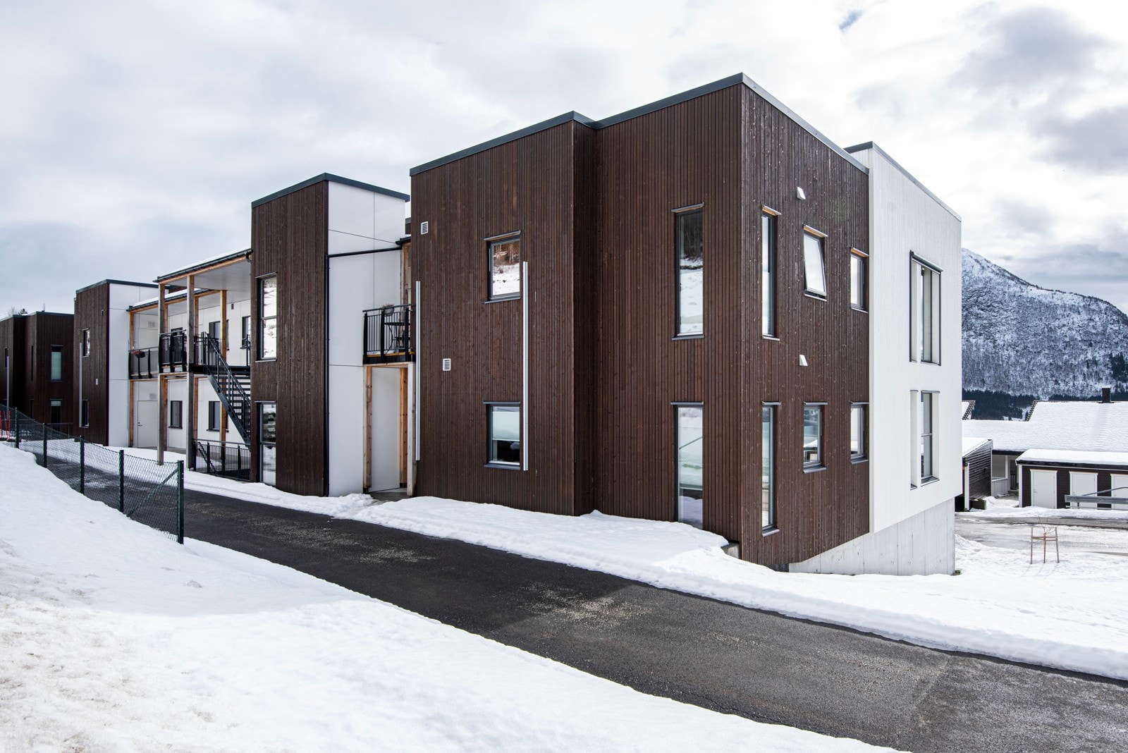 Fasade og inngangsparti på oppsiden av bygget. Det er både heis og trapp fra parkering til etasjen. Galleribilde